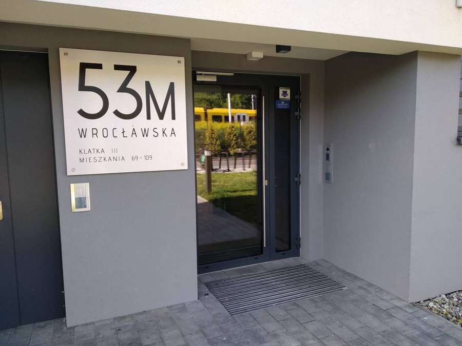 A signed entrance to a residential apartment building in Kraków