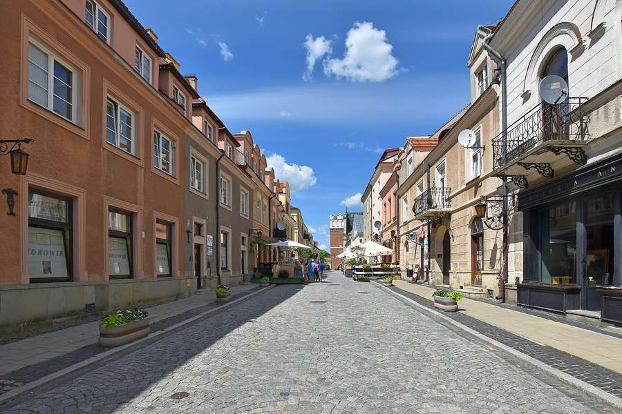 A cobbled old-town street in Sandomierz leading towards the Gothic Opatowska Gate