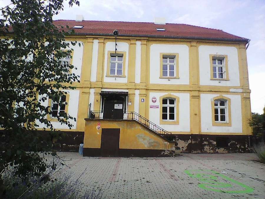 A yellow and white school building in Dolsk, Poland