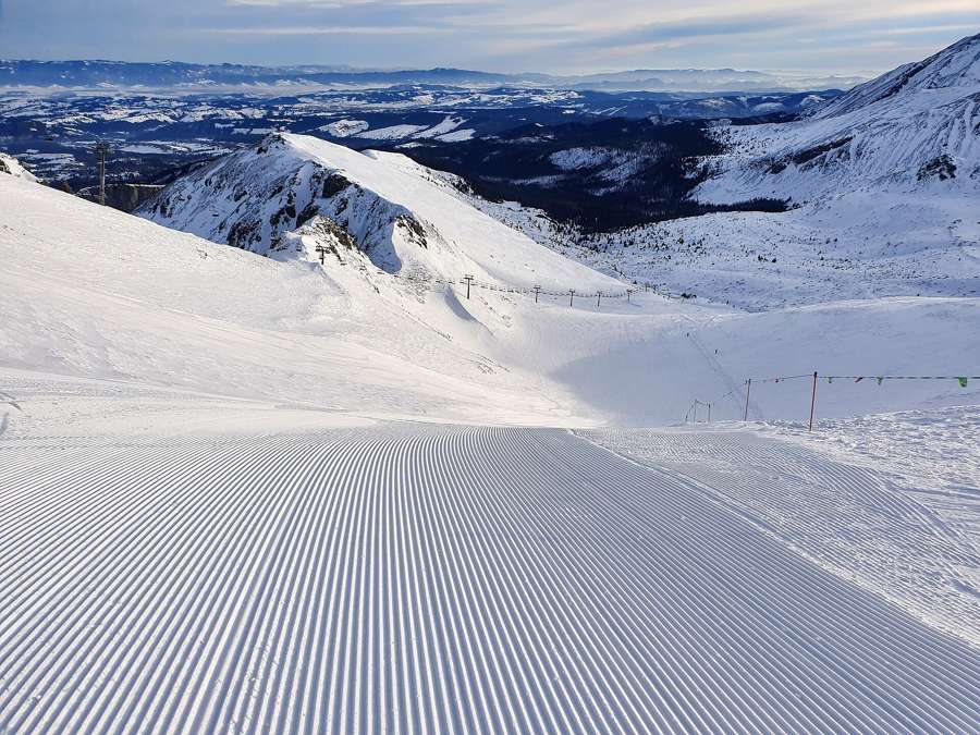 Freshly groomed ski piste on Kasprowy Wierch in the Tatra Mountains with panoramic winter views