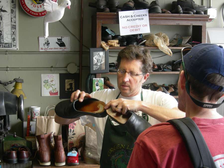 Cobbler examining a shoe at Swanson Shoe Repair in Seattle in 2007, illustrative photograph outside Poland