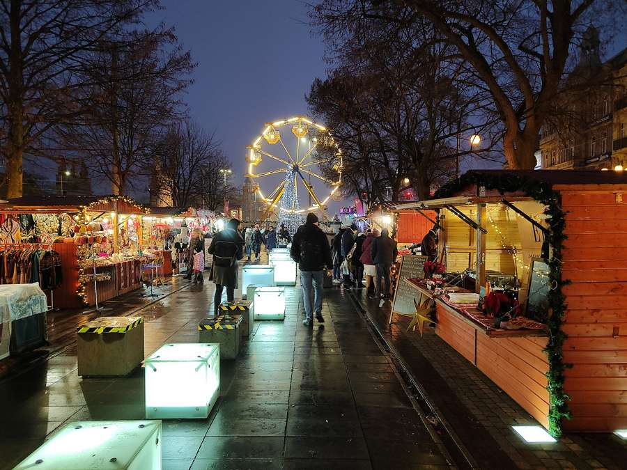 Ferris wheel and wooden stalls of the Szczecin Christmas market lit up at night, December 2022