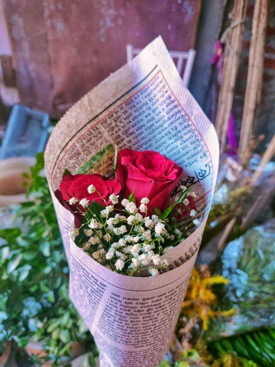 A small bouquet of red roses - the classic Polish date gesture, always in an odd number of stems