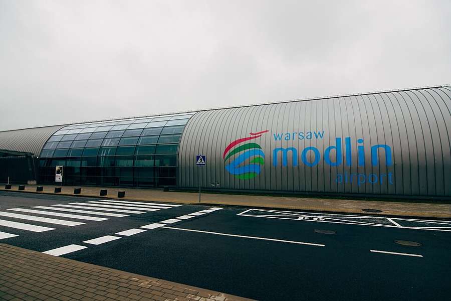 The curved terminal building of Warsaw Modlin Airport seen from the forecourt
