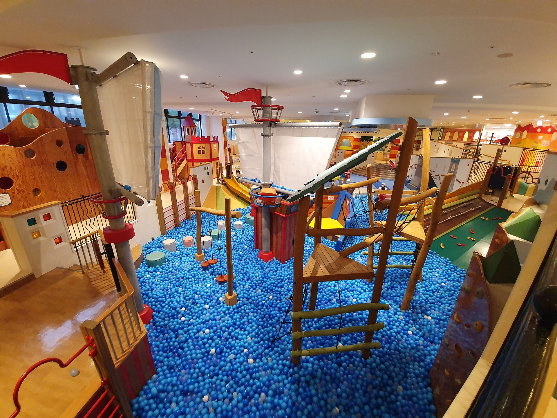A large indoor playground with a ball pool, climbing structures and a wooden ship