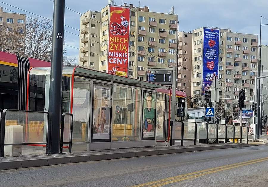A tram at a covered tram stop on Dolna Street in Warsaw with apartment blocks behind