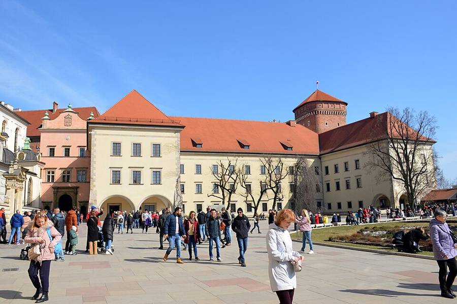 Visitors beside the historic buildings of Wawel Castle external courtyard in Kraków