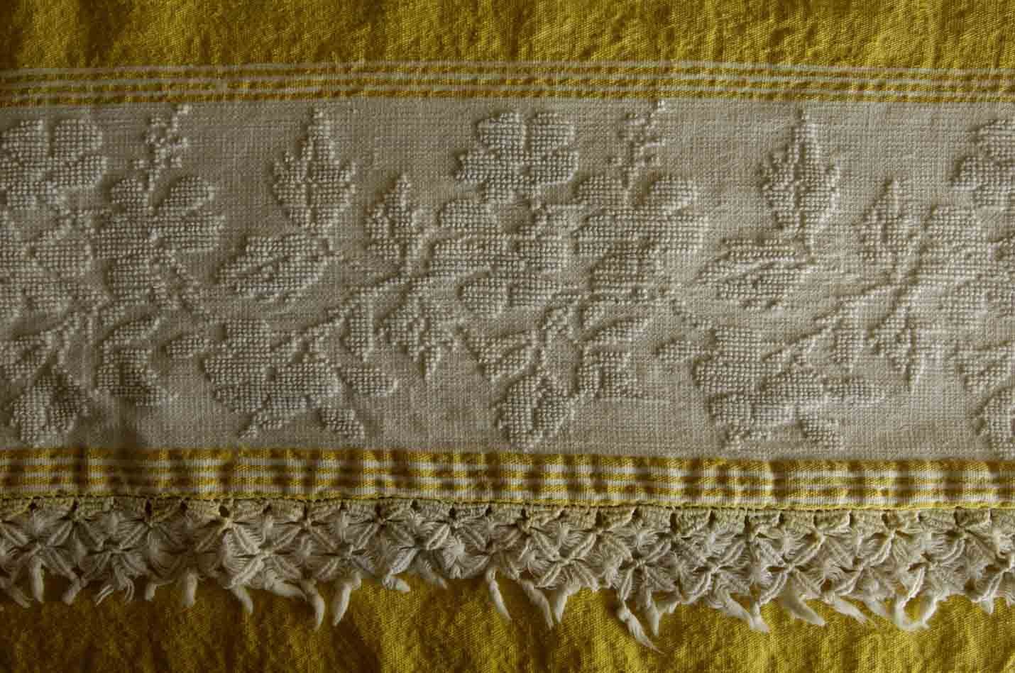 Detail of a pale textile with looped-pile motifs and a fringed edge from SEN Heritage Looms