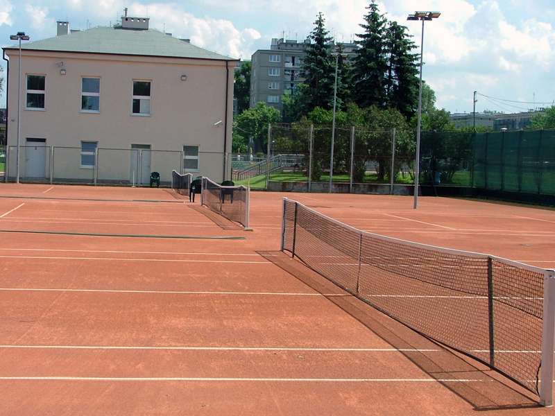 Red clay tennis courts at a Warsaw club with nets and floodlights
