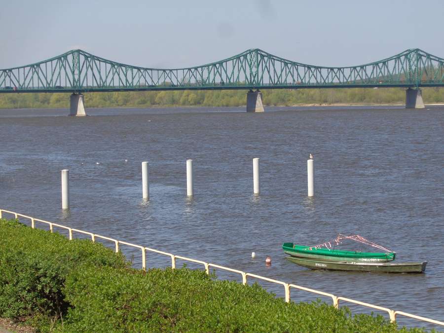The Vistula at Włocławek, with the green steel truss bridge and a moored boat