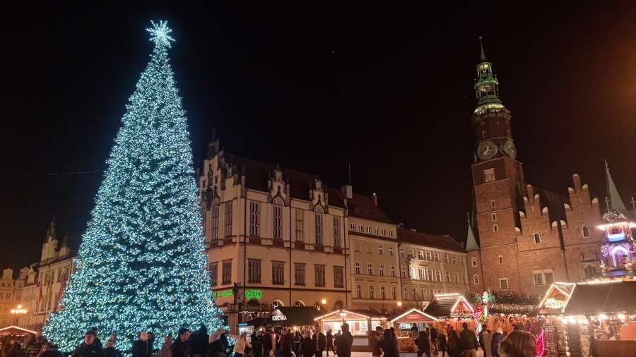 The Wroclaw Christmas market on the Rynek at night, with illuminated wooden stalls