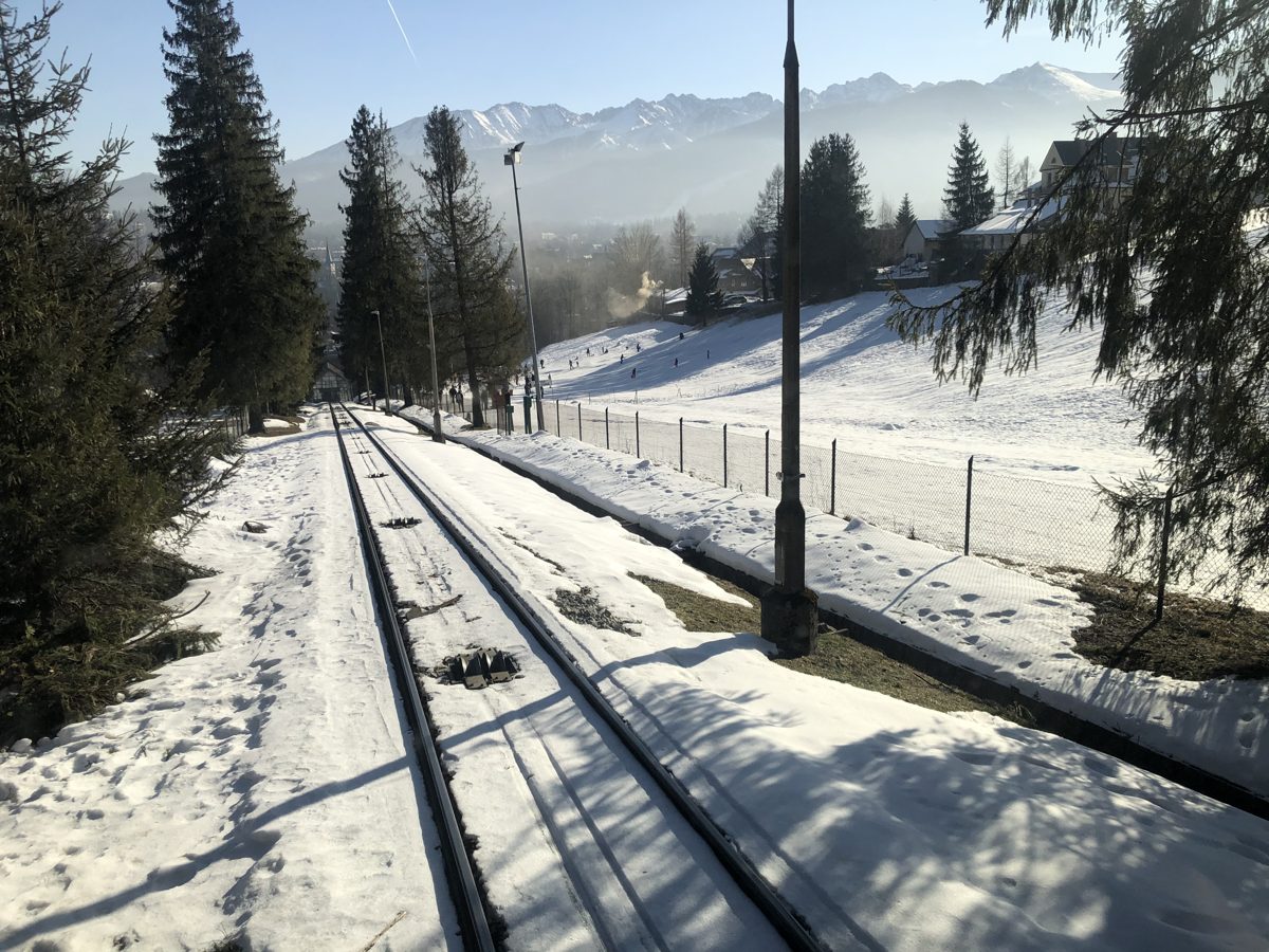 The Gubałówka funicular tracks above Zakopane in winter, with the Tatra range behind