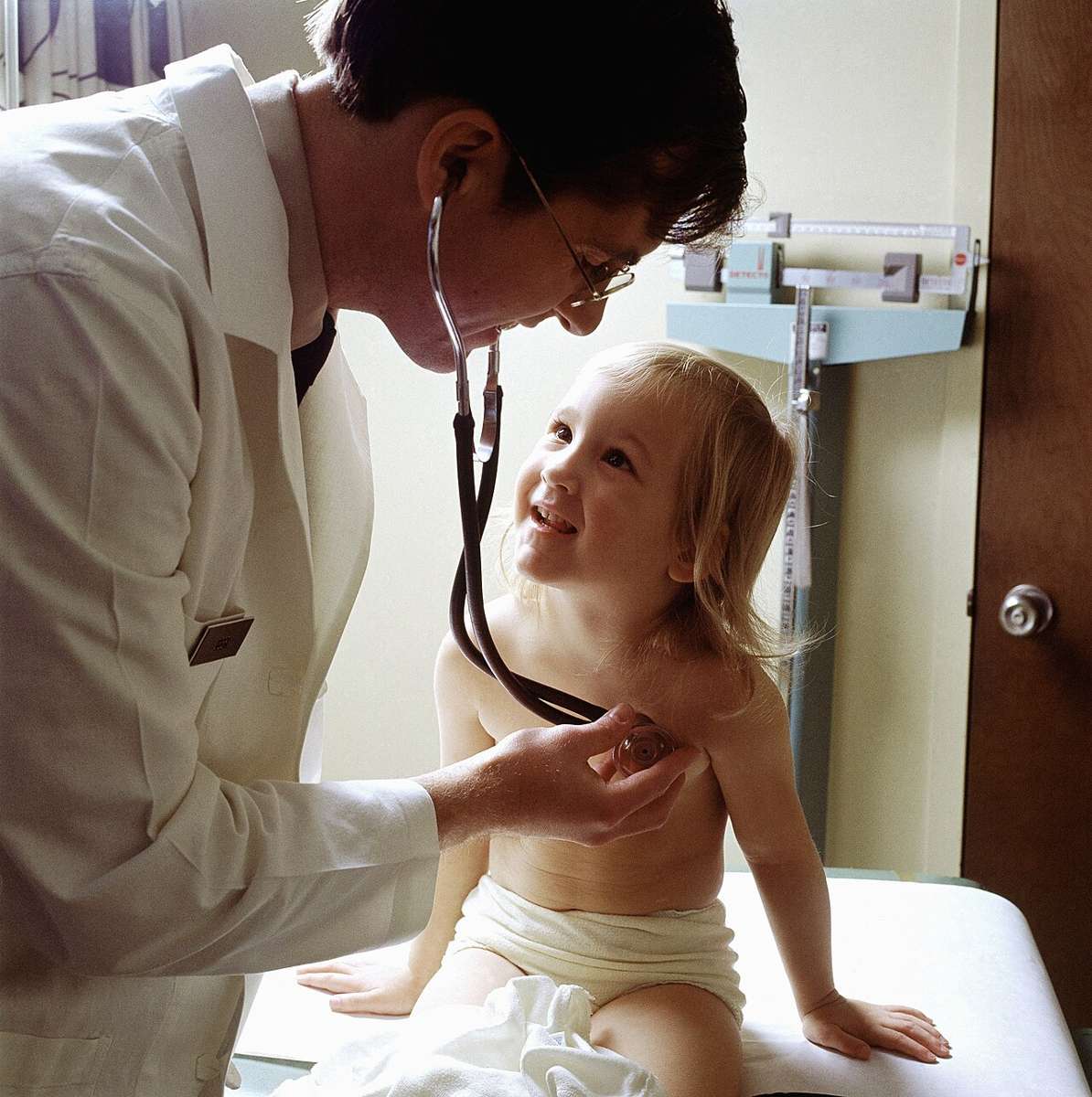 A doctor examining a child with a stethoscope